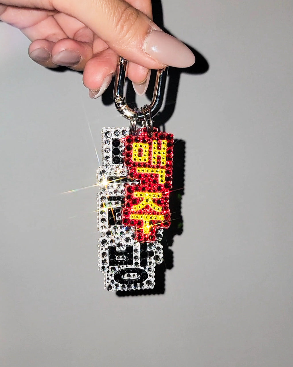 Keychain with colorful design held by a hand against a neutral background