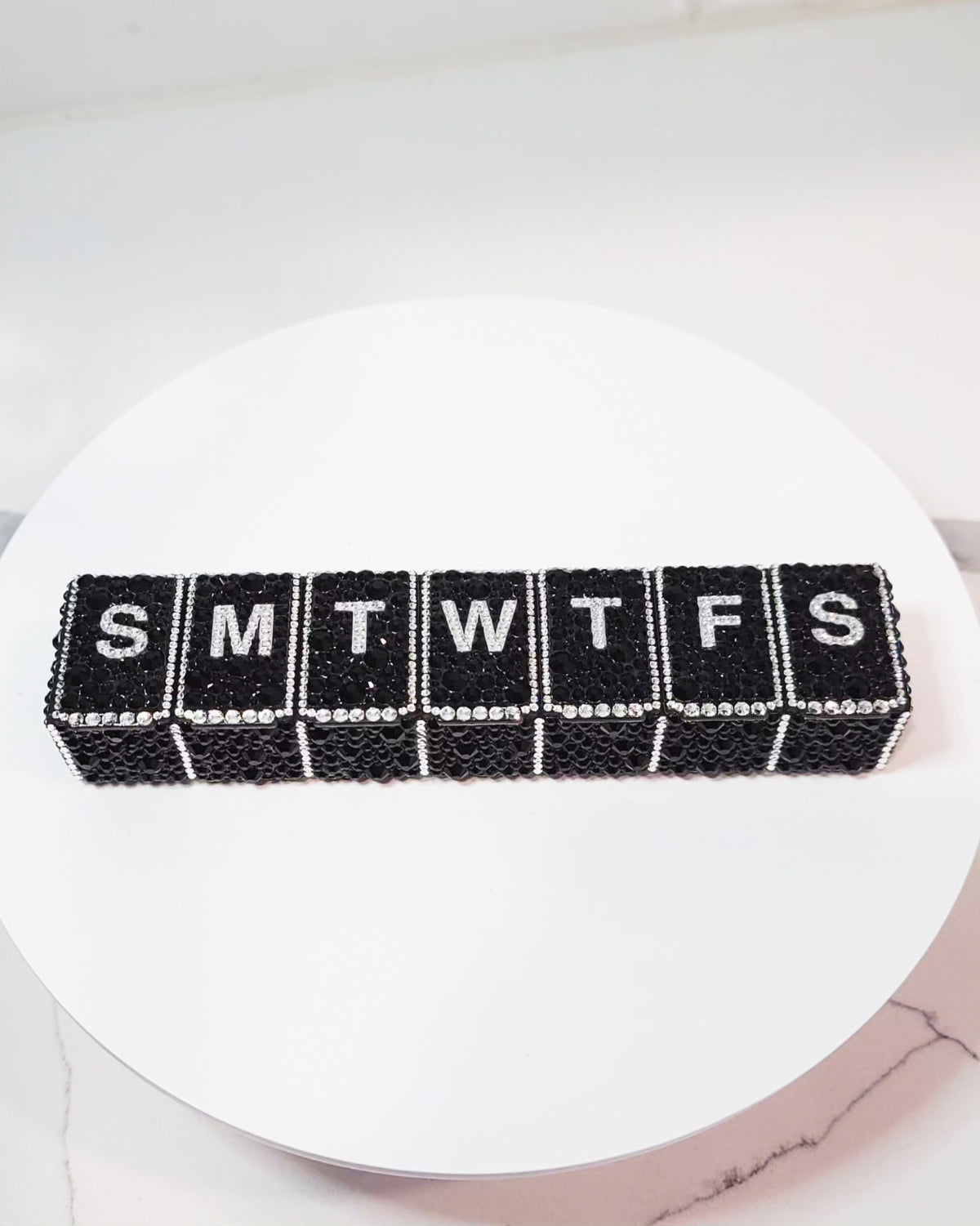 the front of Crystallized Daily Pill Organizer, featuring black rhinestones as the main background, with clear rhinestones as the accents.