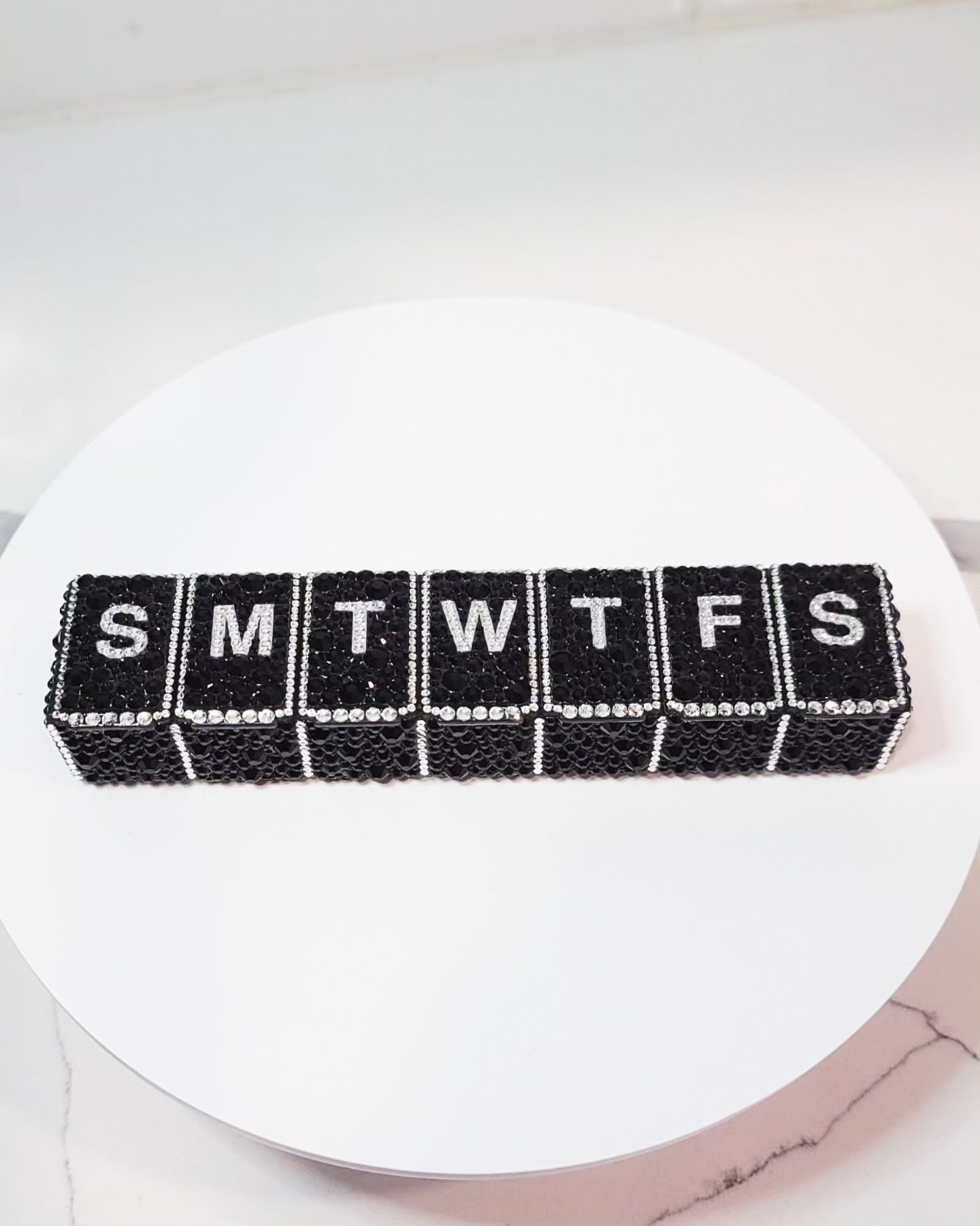 the front of Crystallized Daily Pill Organizer, featuring black rhinestones as the main background, with clear rhinestones as the accents.