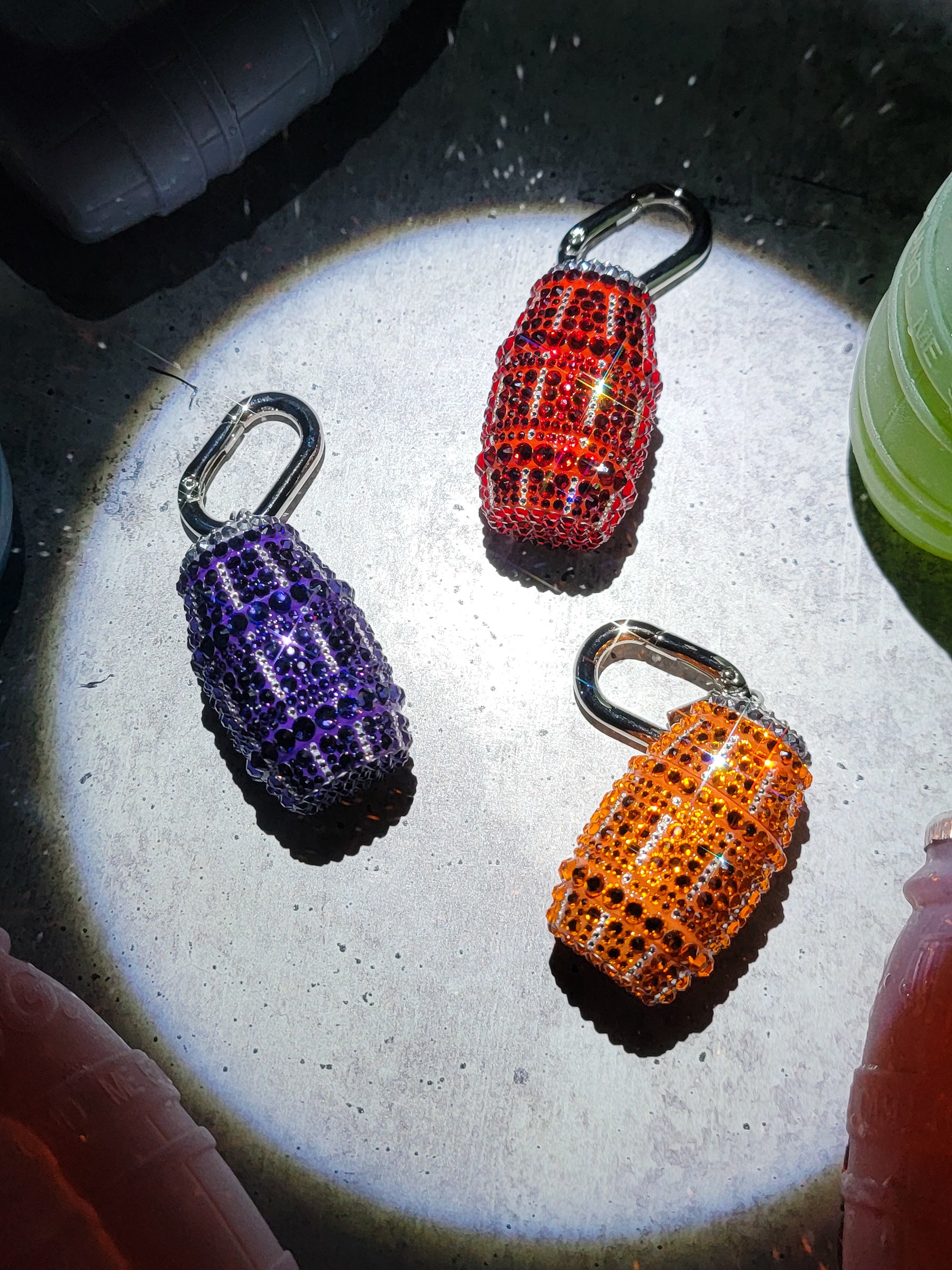 Picture of three quarter waters lying flat on the ground: orange, red, purple.