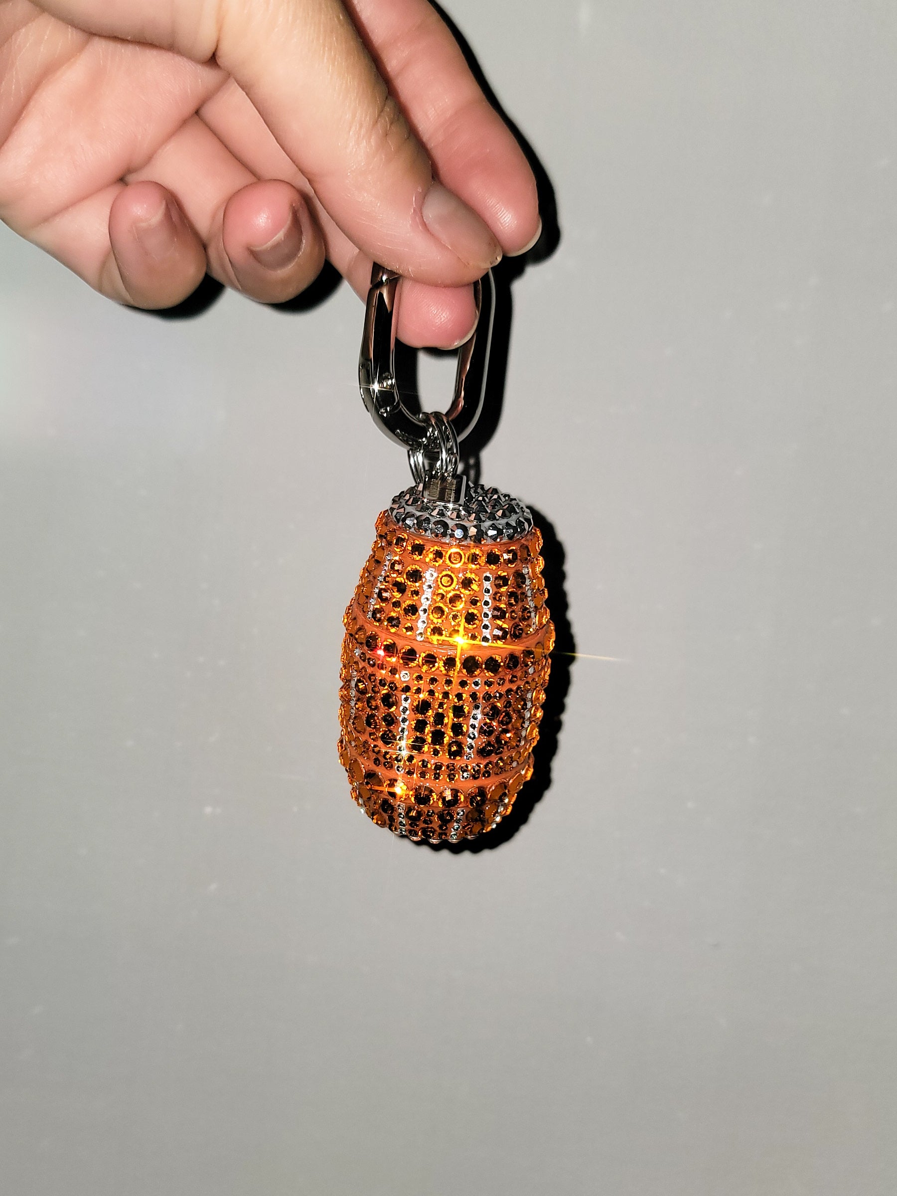 Front picture of Orange Quarter Water Bag Charm with a gray background.