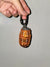Front picture of Orange Quarter Water Bag Charm with a gray background.