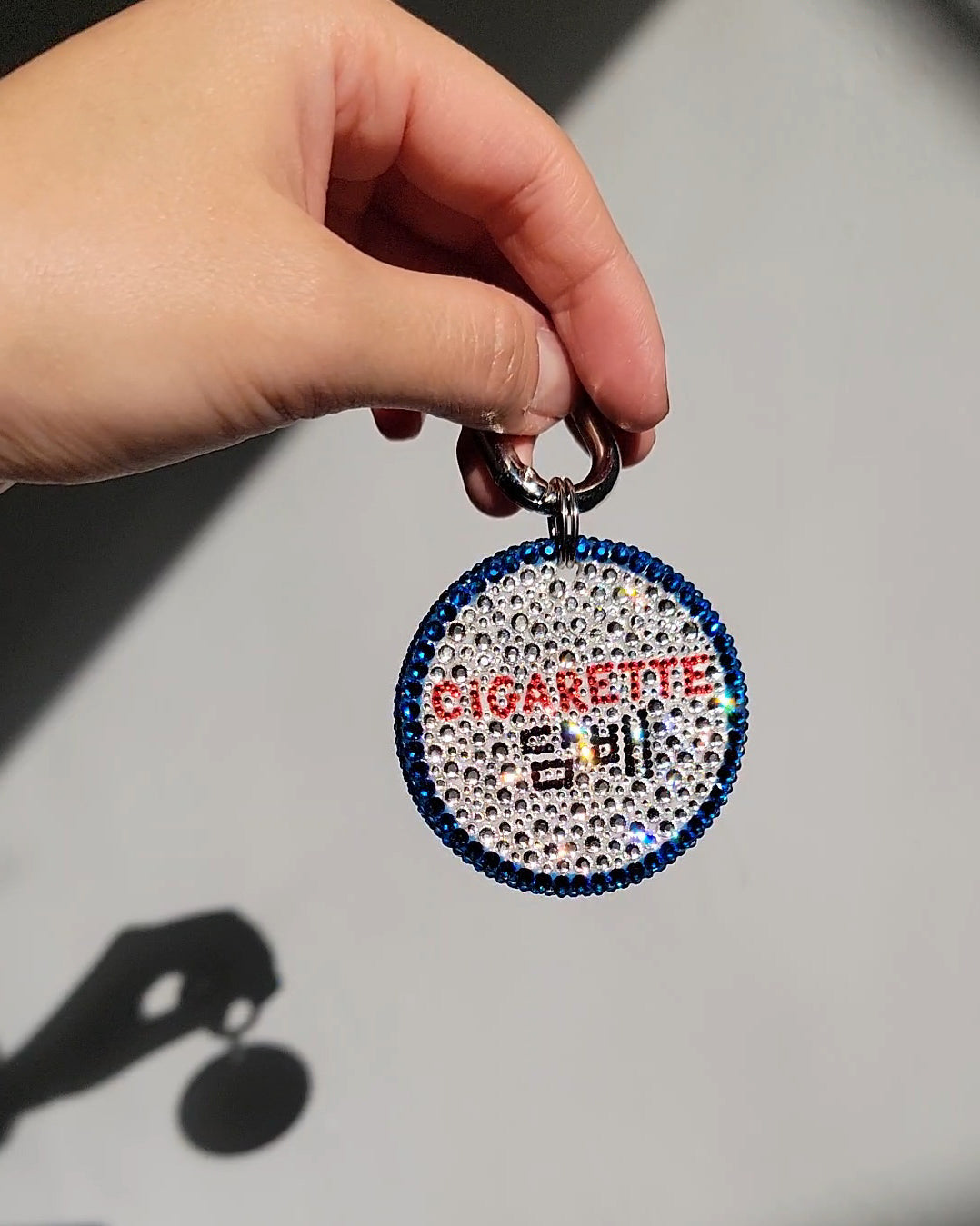 One side of the Nightlife Cigarette Sign Bag Charm, featuring prominent English in red, with hangul beneath in black.