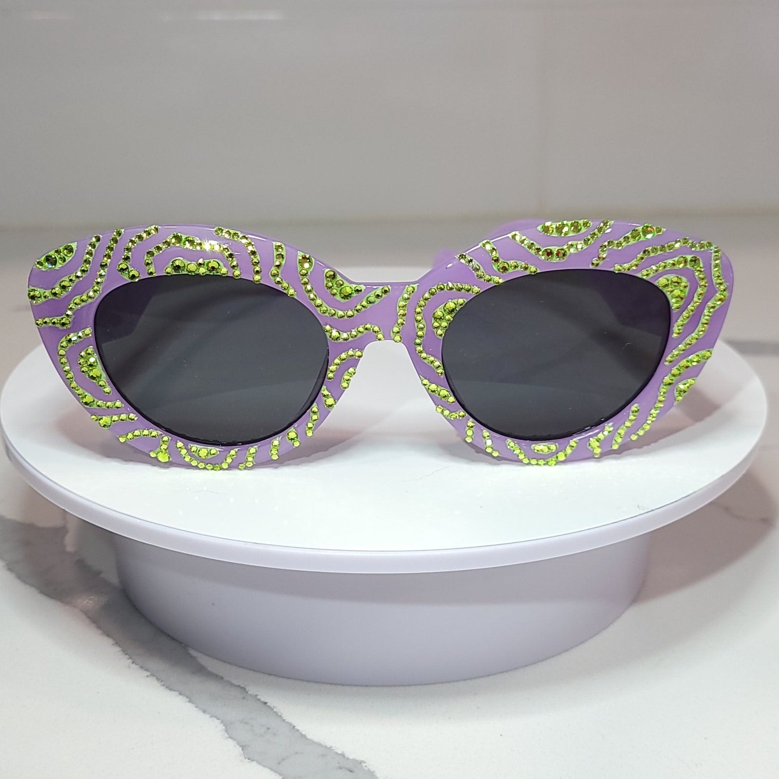 Matcha Nightmares Sunglasses Front, a pair of lavender sunglasses with handdrawn green swirls, and green rhinestones.