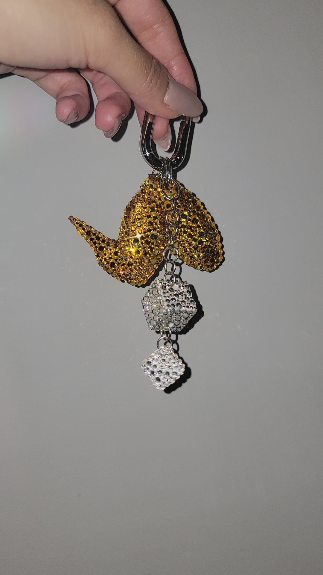 Video of Wingz Bag Charm being rotated against a gray background.