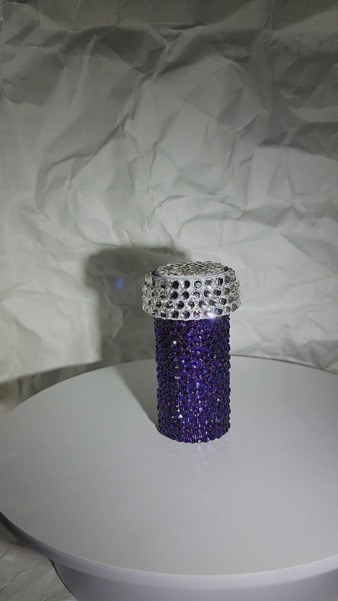 Video of the Dancheong Pill Bottle, being rotated on a white surface, against a white, crumpled paper background.