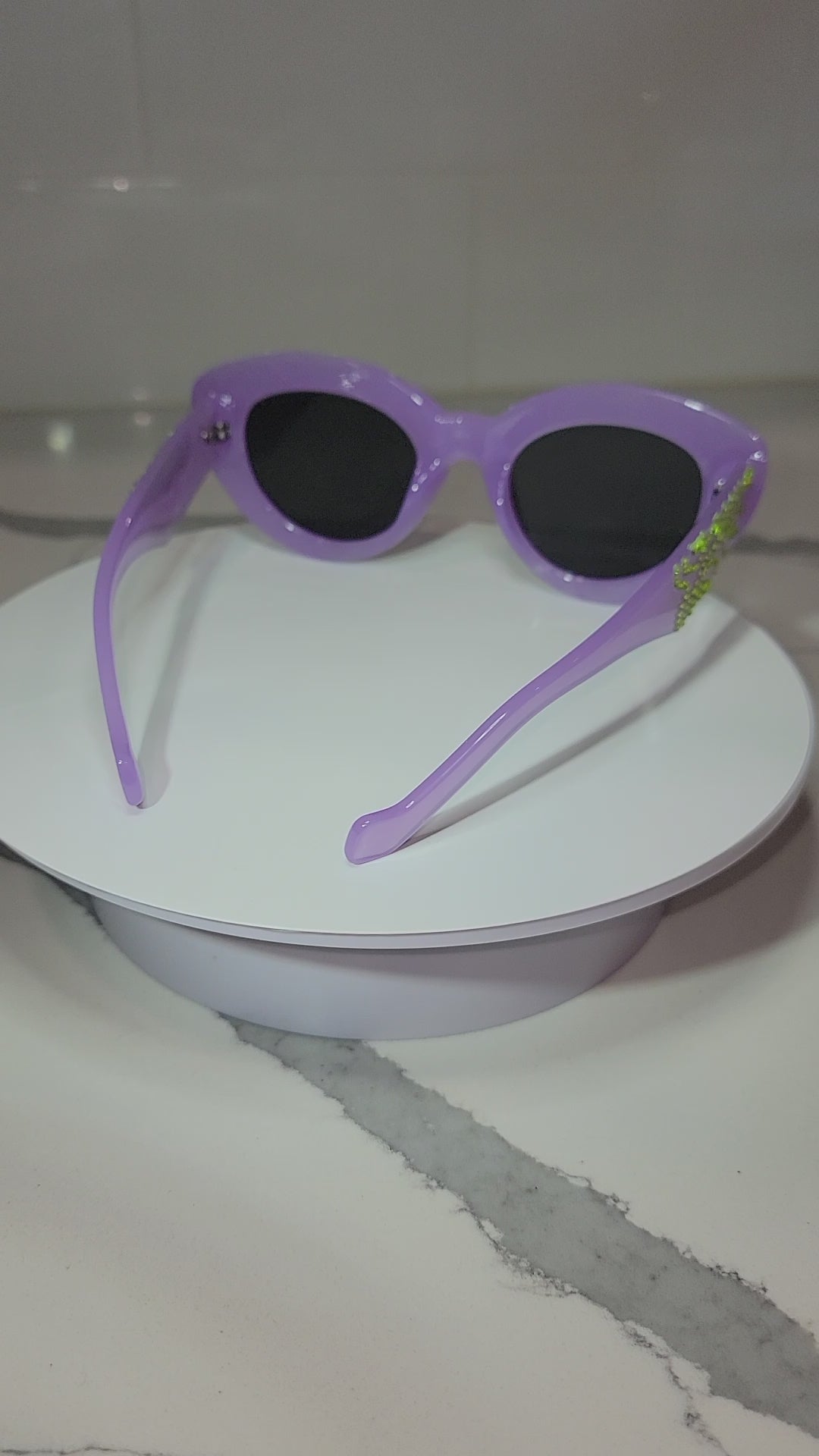 Acid Nightmares Sunglasses Video with Inside Light, being rotated on a white surface against a marble countertop.