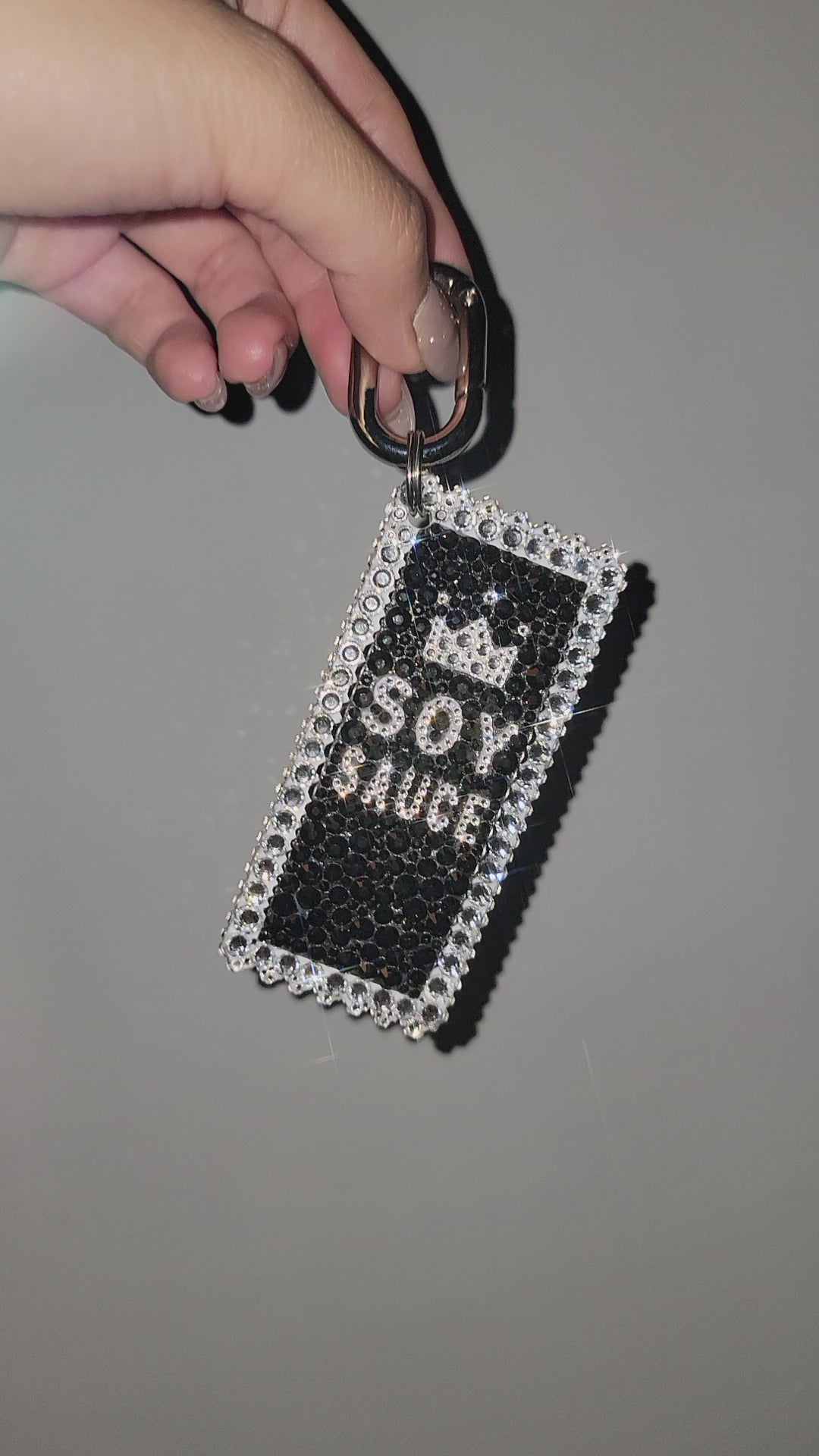 Video of Soy Sauce Charm being rotated inside, held by hand against a gray background.