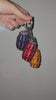 Video of purple, orange, and red quarter water bag charms being held up against a gray background.
