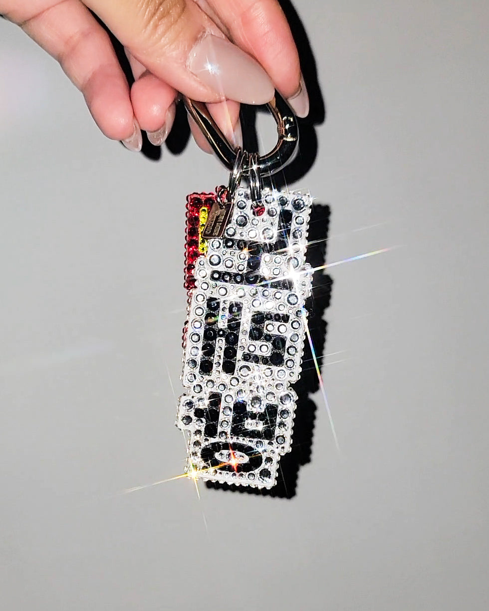 Back of Nightlife Karaoke Sign Bag Charm, being held against a gray background.